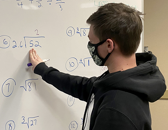Teen student writing on a white board