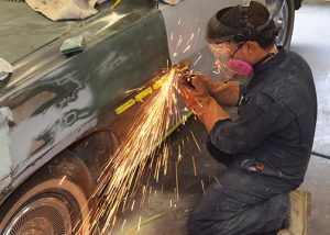 Sparks fly as an auto body student works on a car's quarter panel.