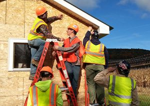 Students in safety vests working on the outside of 