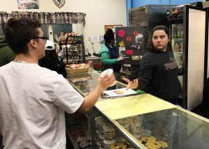 Two students interact in a classroom mock-up of a retail store.