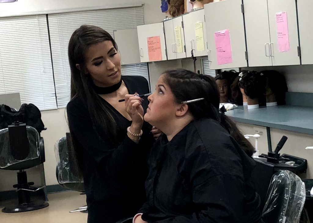 2015 Career & Technical School alumna Chantel Urban teaches makeup skills to Cosmetology student.