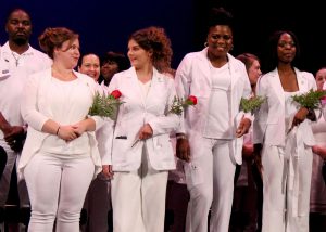 CTE Adult Nursing students stand arm-in-arm at their June 26 graduation ceremony.
