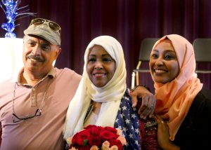 A recent graduate of Capital Region BOCES Adult Education program holding a bouquet of roses smiles for the camera.