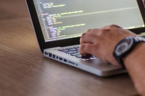 picture of a person's hand typing on a computer 