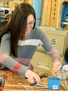 Career and Technical School student Quinn Rickard cuts wires with a hand-held tool.