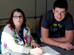 Teaching Assistant Colleen Condolora works with a student on his math homework.