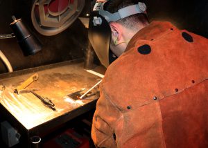 A mechanical engineer from Knolls Atomic Power Laboratory wearing protective clothing tries his hand at welding at Capital Region BOCES.