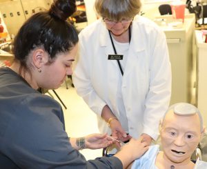 Adult Nursing student learns to give an injection from a program teacher.
