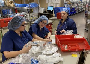 Sterile Processing program graduate Rosa Friere works with students in a hospital clean room.