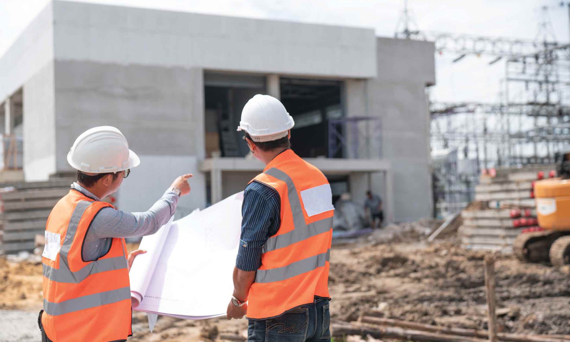 Two construction workers look on to project in progress.