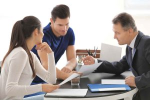 Three people work on a project at a table together.