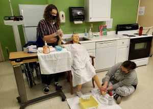 Two students in a Capital Region BOCES Health Careers Classroom attend to a patient. 