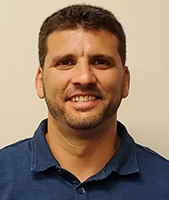 Schoharie Career and Technical School Principal Matthew Ward, who has short brown hair and a closely trimmed beard and mustache, looks at and smiles for the camera.