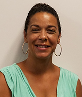 Albany Campus Career & Technical School Principal Shelette Pleat, with dark brown hair pulled back in a bun and wearing a mint green draped top, looks at and smiles for the camera.