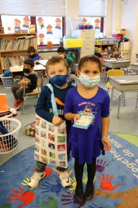 Watervliet kindergarten students holding a STEM tote bag for families to complete at home.