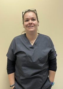 Cassidy Knapp, wearing grey scrubs, smiles for the camera.