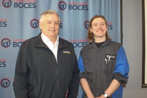 Bill May and Tucker Cherry pose smiling in front of a blue backdrop that has the Capital Region BOCES logo in navy and red.