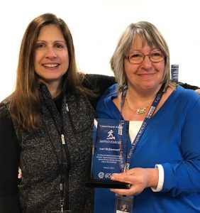 Marlene MacFee to the left and Lori McDermott on the right, hugging as Lori holds an award.