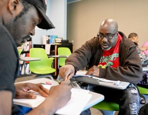 A student working on electrical wires with her instructor