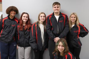 Six students wearing SkillsUSA branded jackets smiling.