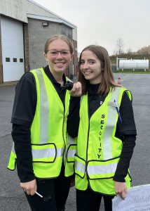 Students Madison Westerman and Rhiannon Islip wearing yellow security vests, smiling.