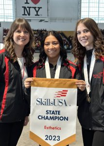 Three individuals hold up a SkillsUSA state championship banner.