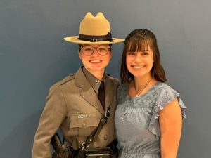 A former student, dressed in a state trooper uniform, and friend stand together for a photo opportunity.