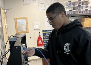 A student looks over his work with network cabling.