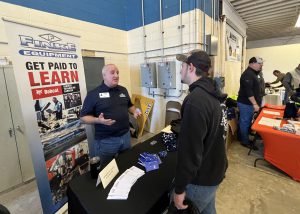 A Capital Region BOCES students stands and listens as a representative from a local business shares details about his company at a recent Career Day fair.