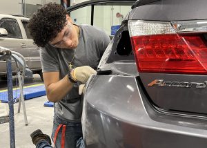 Fixing a big bump requires attention to detail while working on automotive repair.