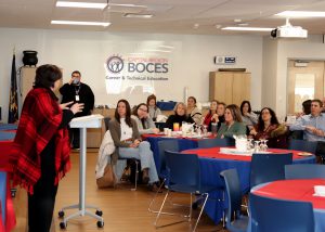 A guest speaker behind a podium shares insight to a crowd of people at the Capital Region BOCES and Technical Education Center.