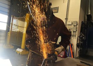 A shower of sparks splashes across a welder's mask.