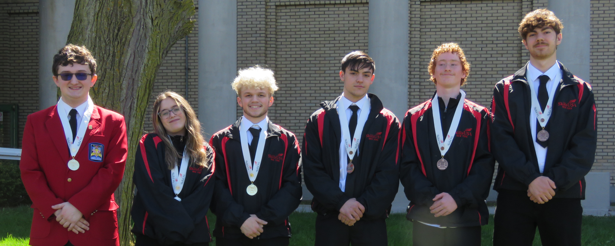 Students stand in line medals around their necks.