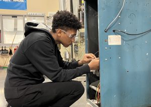 Class of 2024 grad JJ Jackson works on a furnace