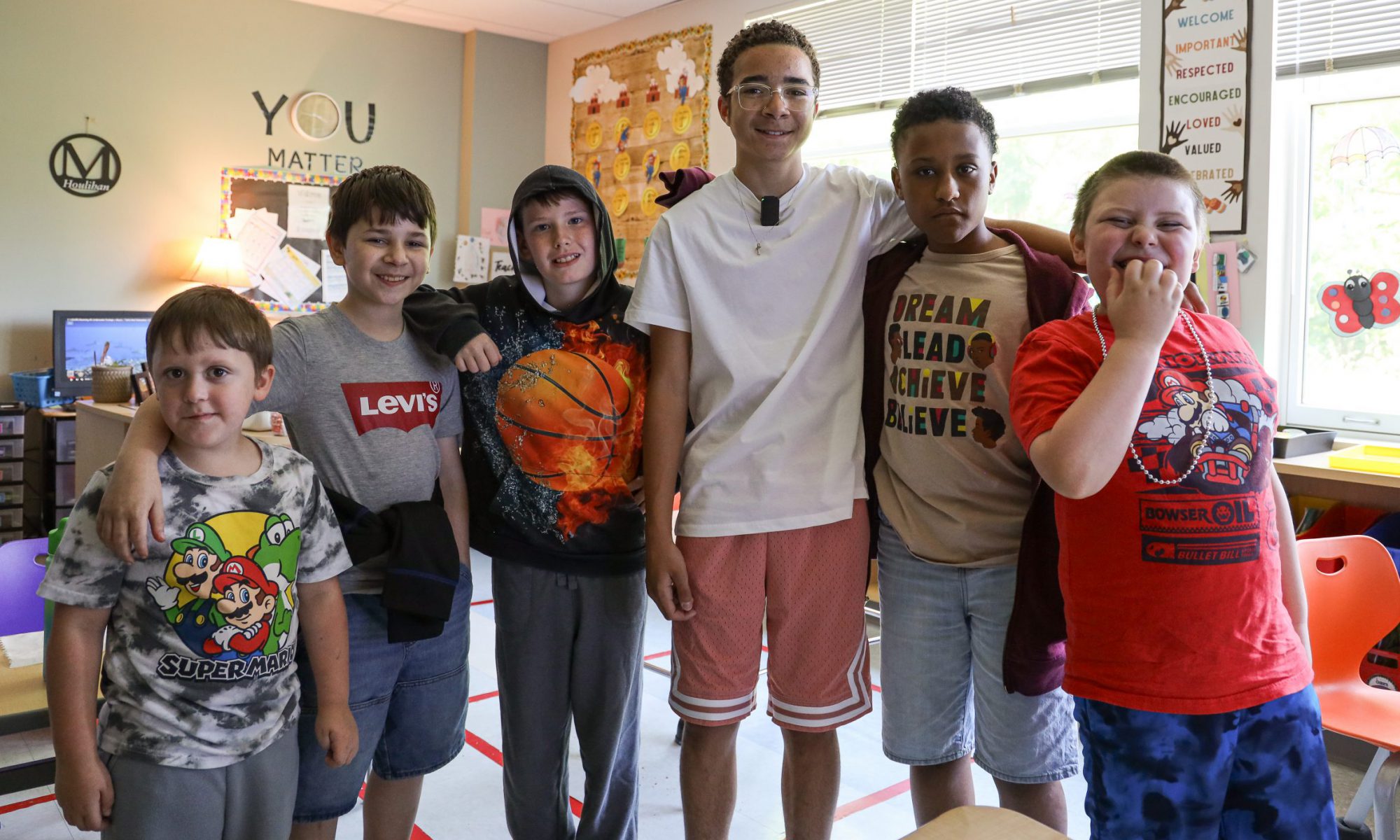 five students pose and smile