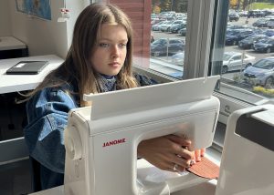 Student sews using a machine