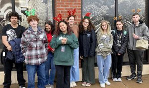 Students pose in front of a shelter