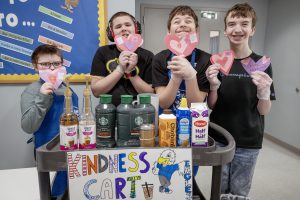 This is a group photos of students at Airline Academy. From left to right is Carter Parker, Jakob Rickson, Liam Brannigan and Joey LaVare hold their Kindness notes at their Kindness Cart.