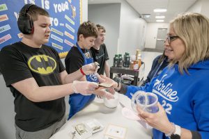 Airline Academy student Jakob Rickson counts change for Principal Barb Lounello at their Kindness Cart at Airline Academy. 