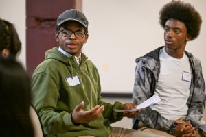 A student speaks while another listen attentively.