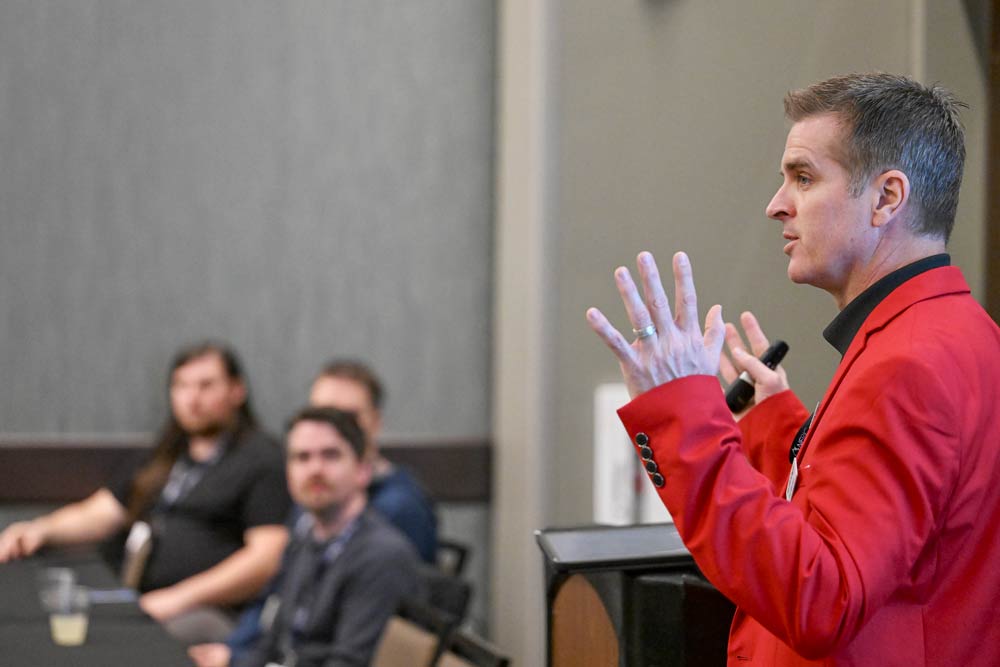 Instructor gesturing with hands as he teaches a class of adults