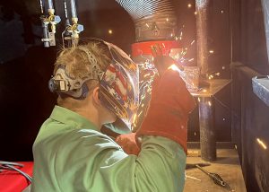 A student welds, generating sparks