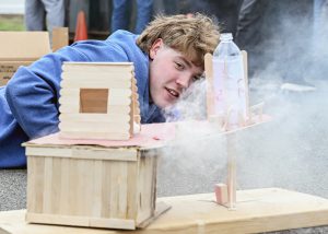 A student peers into a smoking house