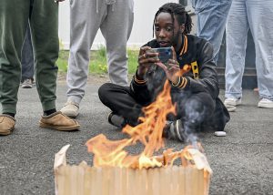 A student photographs a flaming house