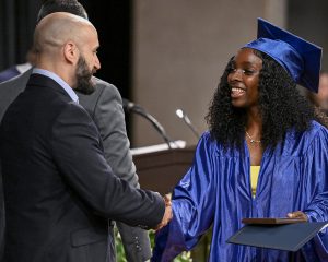 student smiles and shakes hands