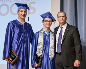 two students pose with a teacher