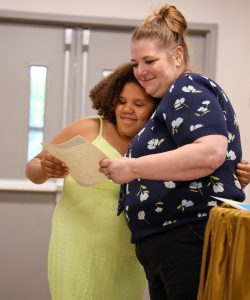 Student and teacher share a hug during a moving up ceremony at Airline Drive Academy.