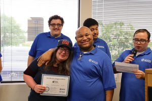 SELFI Program graduates pose for a picture with a representative from the Regional Food Bank as the rep is given a certificate of appreciation. 