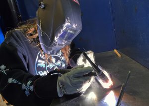 An adult welds
