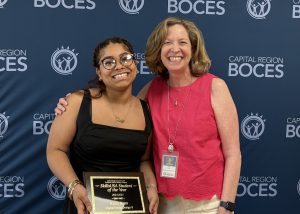 A student and advisor pose and smie